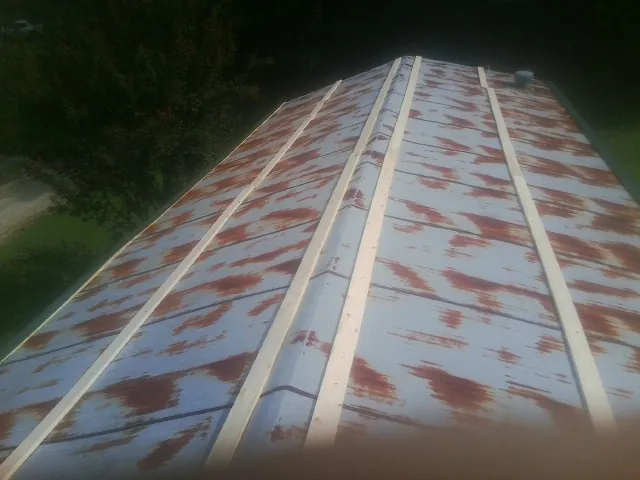 Rusted metal roof panels with new wood purlins before replacement — Storm Damage Roof Repair in Gulf Breeze by Roofing Brothers