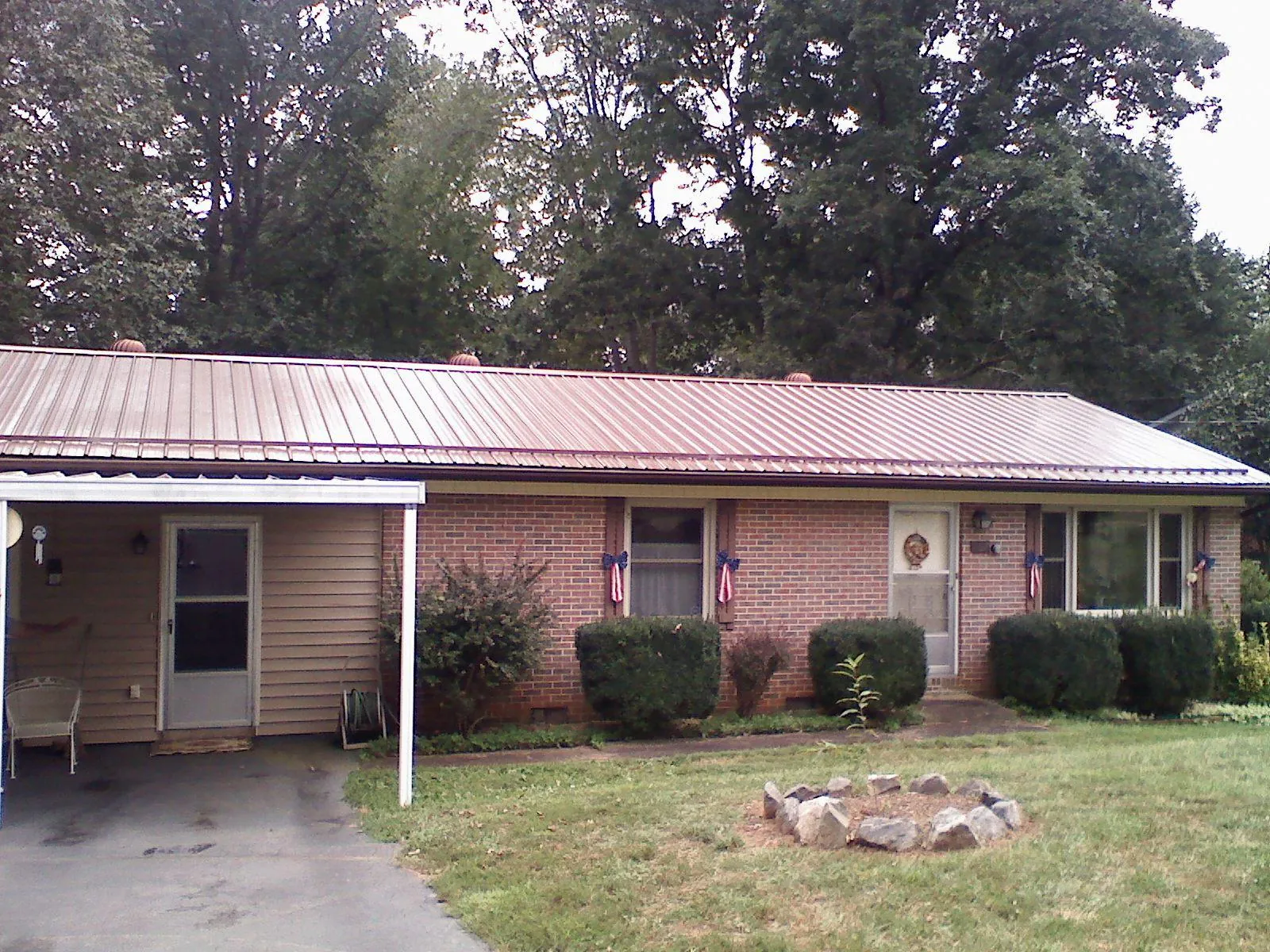 Bronze metal roof and carport on a brick ranch home — Roof Repair work by our crew in Gulf Breeze