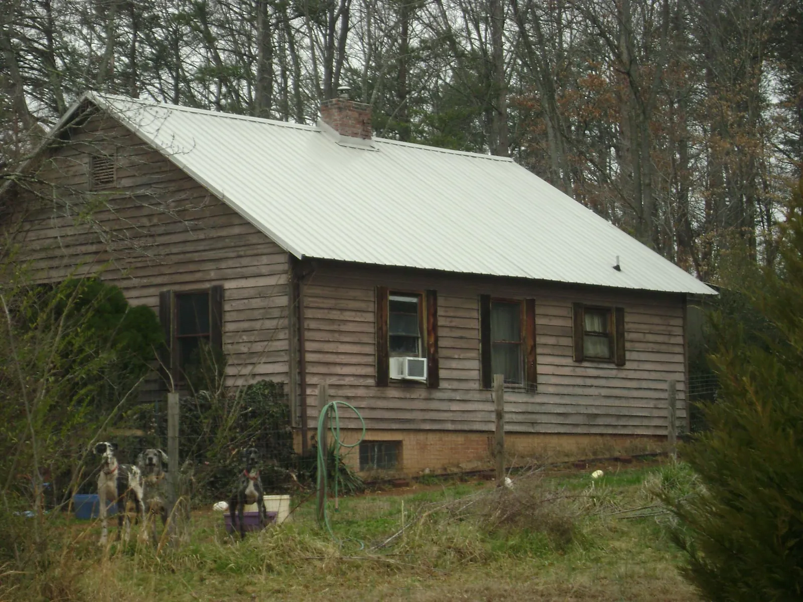 White metal roof on an old wood sided farmhouse, from a Metal Roof Installation job in Gulf Breeze